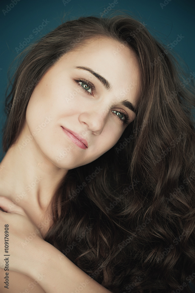 Naklejka premium Beautiful young woman with big eyes and curly hair smiling. Beau