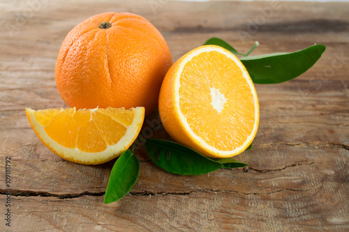 Oranges fruit with leaves on wooden background