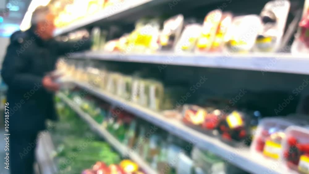 Man chooses vegetables in a supermarket Man chooses vegetables in a supermarket