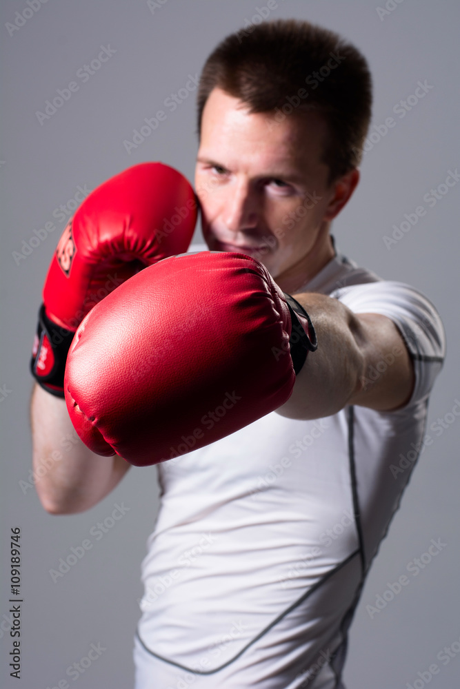 Boxer in attack position on a gray background Boxer in attack position on a gray background