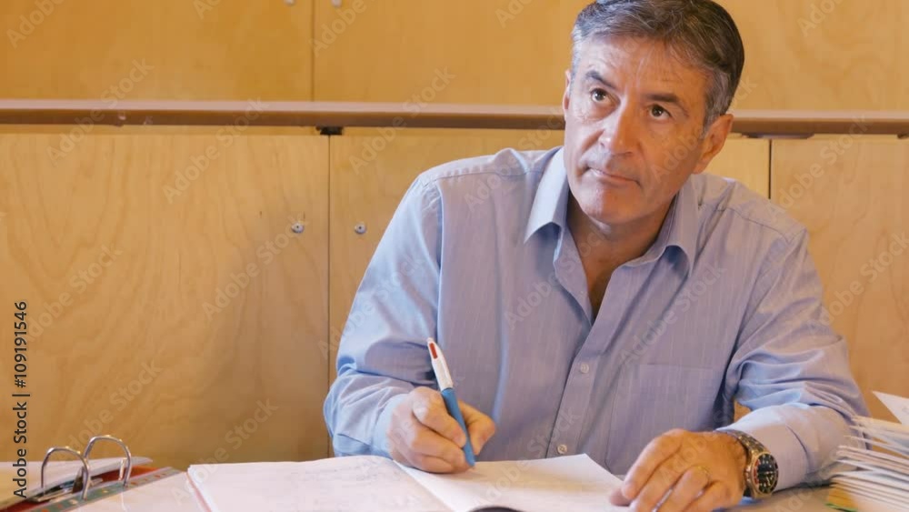 Handsome teacher grading some papers