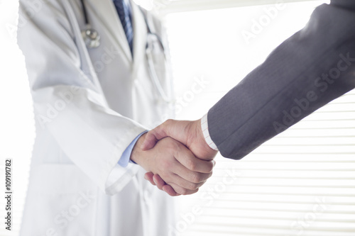 握手する医師とビジネスマンの手