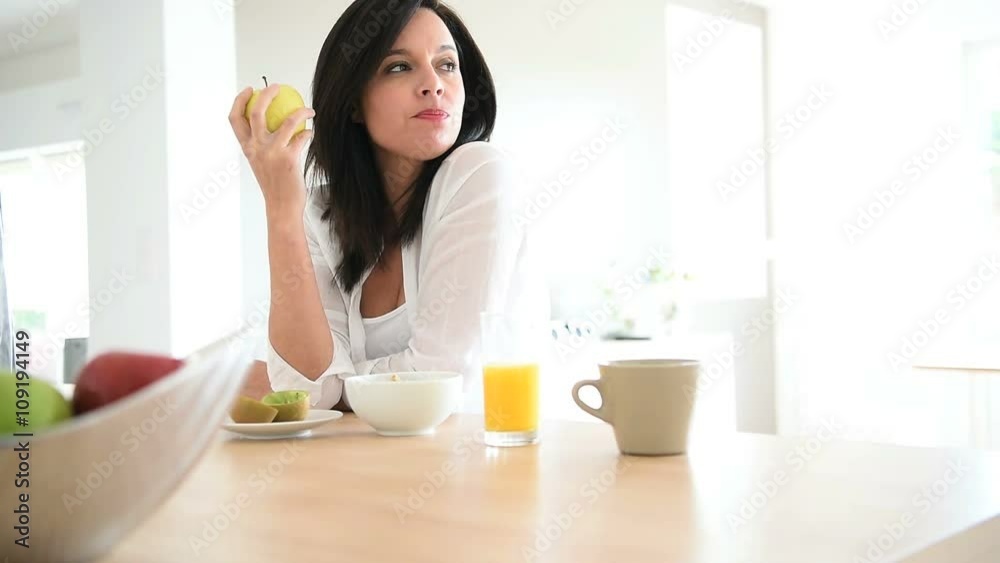 Mature woman eating apple for breakfast Mature woman eating apple for breakfast
