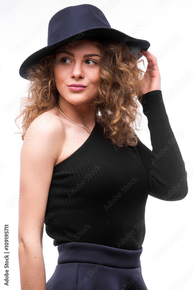 woman with curly hair in black hat and stylish elegant evening dress posing on white studio background. woman with curly hair in black hat and stylish elegant evening dress posing on white studio background.