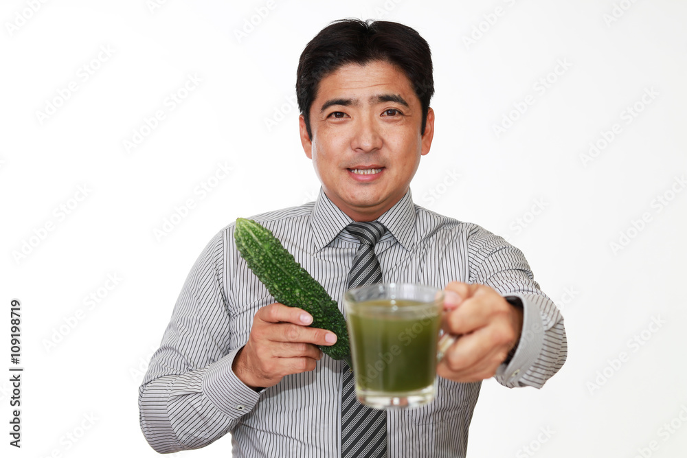 野菜とジュースを持つ笑顔のビジネスマン