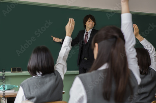 教師と手を上げる女子生徒