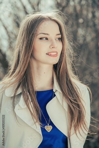 Portrait of a beautiful girl. Cold spring, windy weather.