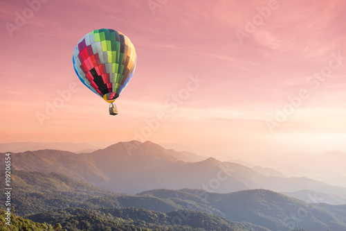 Hot air balloon over high mountain at sunset