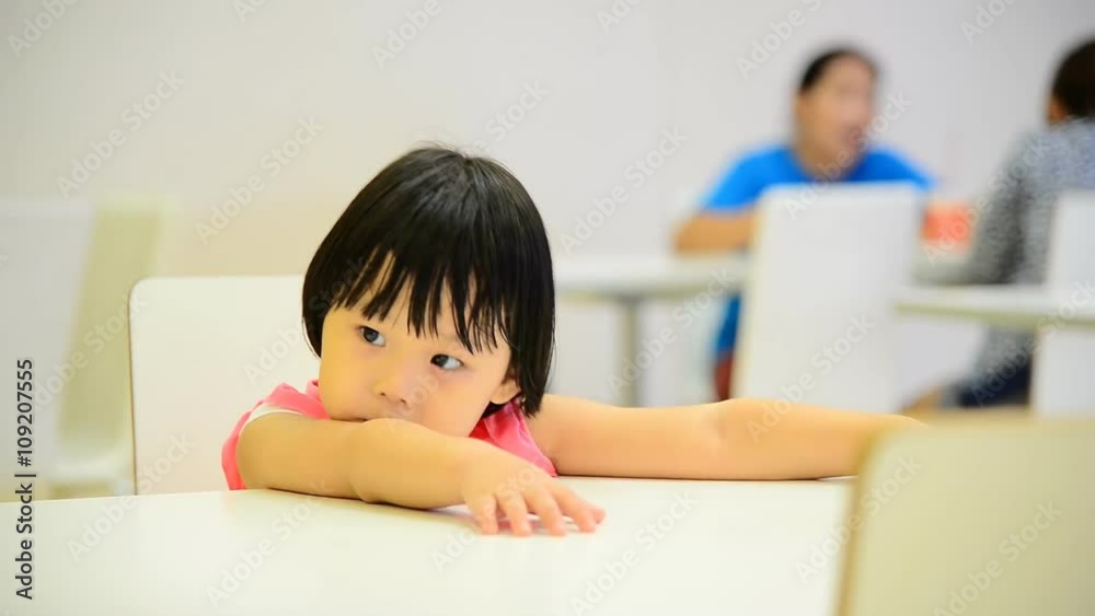 Asian girl sitting at food court in supermarket Asian girl sitting at food court in supermarket