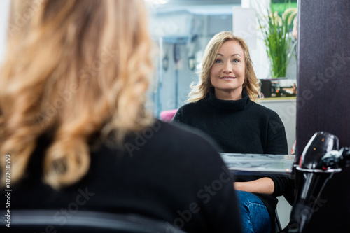 Reflection Of Female Customer Smiling In Salon