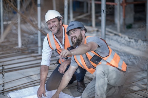 Tablou pe pânză Site manager and builder with blueprint on construction site