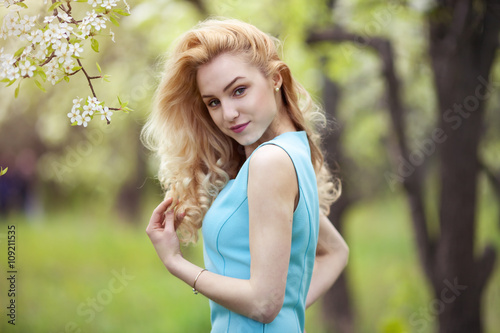 Beautiful woman spring portrait, smiling girl with flowers outdoor, carefree young woman on nature