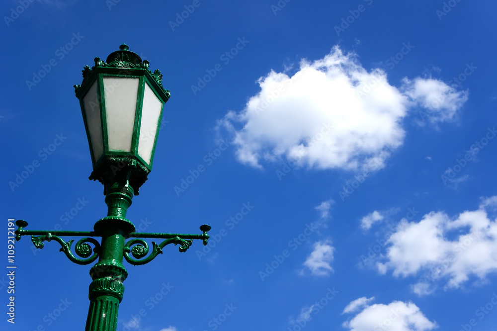 green lamppost on background of blue sky