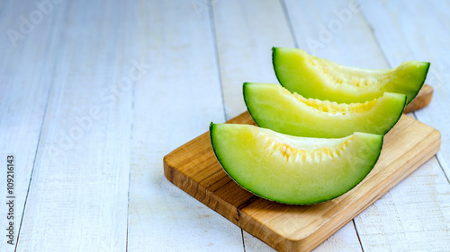 Fresh green melons sliced on wooden board place on table