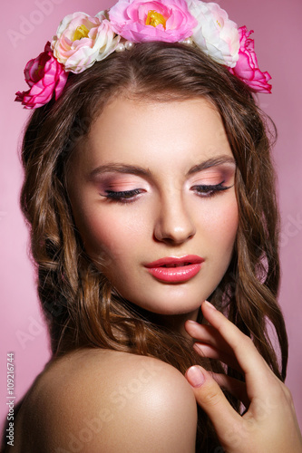 Portrait of beautiful bride. Wedding makeup.Portrait of a beautiful woman in the image of the bride with flowers in her hair. Picture taken in the studio on a pink background.
