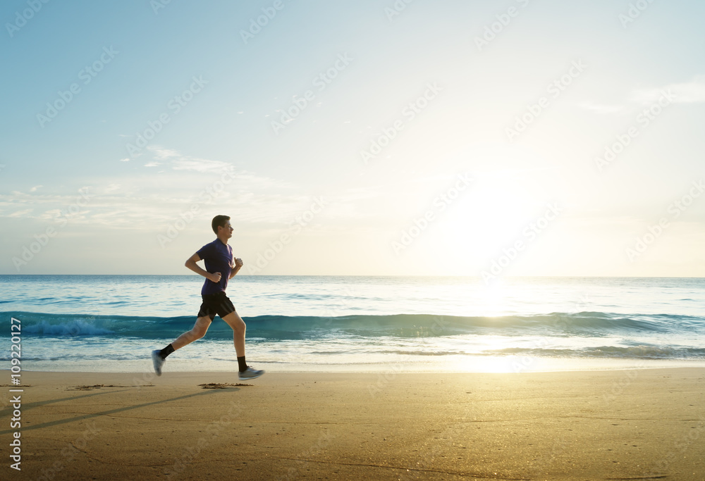 Fotografie Man running on tropical beach at sunset