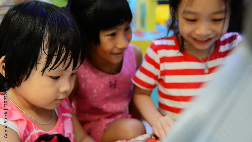Asian children play computer game with touchscreen in supermarket Asian children play computer game with touchscreen in supermarket