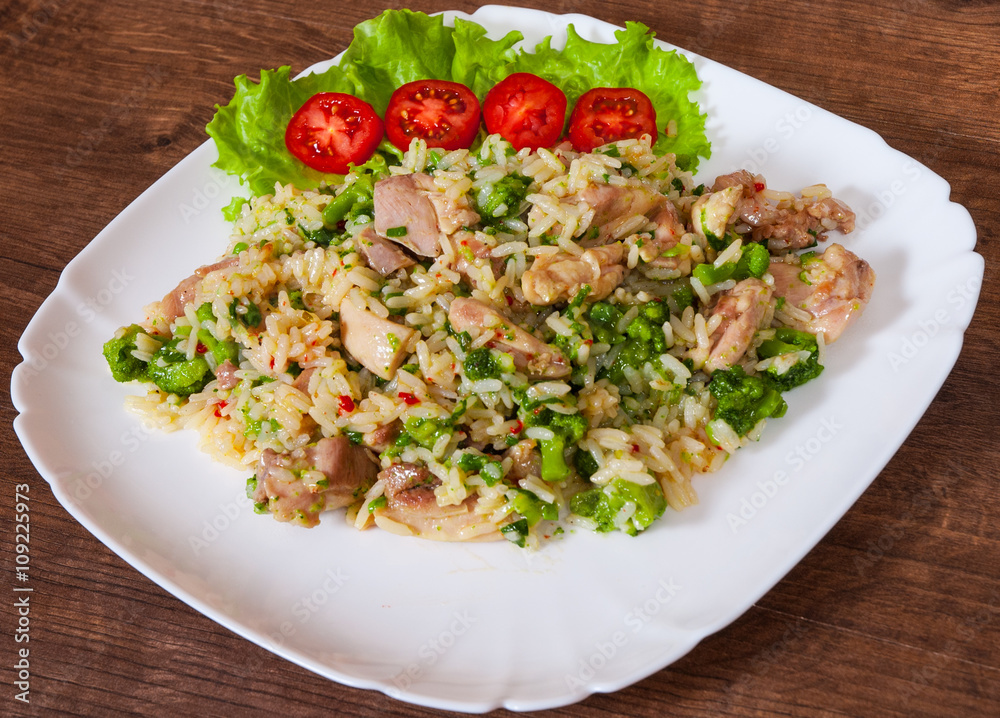 chicken meat with rice and vegetables in a plate on wooden table chicken meat with rice and vegetables in a plate on wooden table