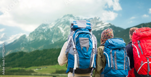 travelers with backpacks hiking in mountains