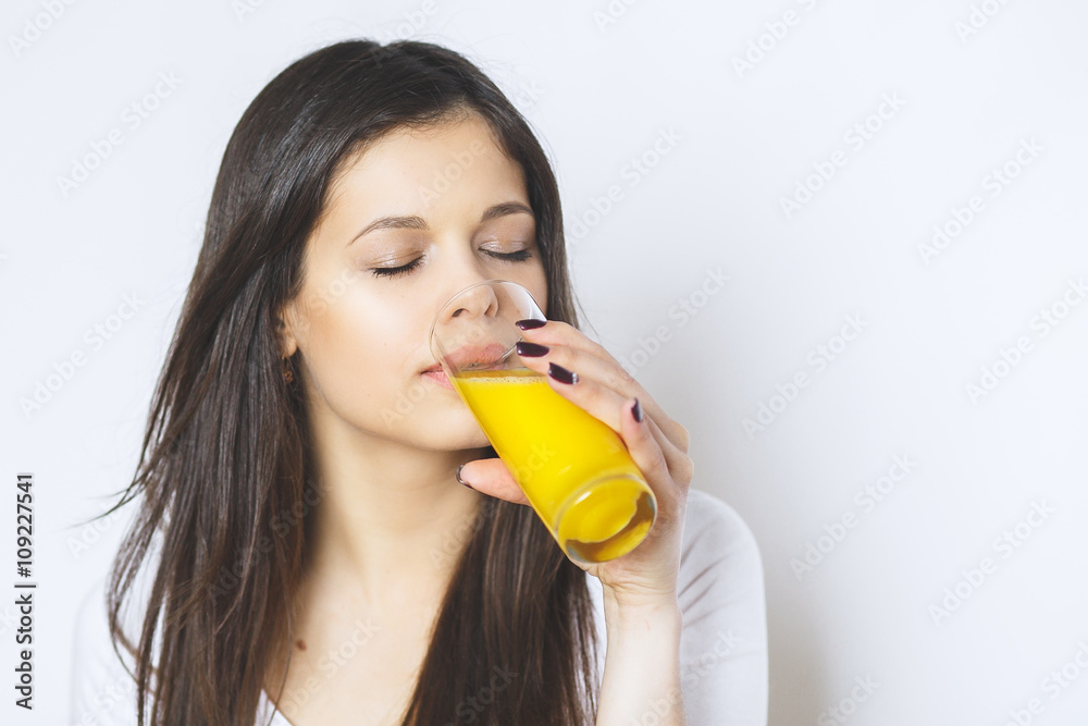 Portrait of attractive caucasian smiling woman isolated on white studio shot drinking orange juice face skin. Portrait of a pretty woman holding glass with tasty juice . Portrait of attractive caucasian smiling woman isolated on white studio shot drinking orange juice face skin. Portrait of a pretty woman holding glass with tasty juice .