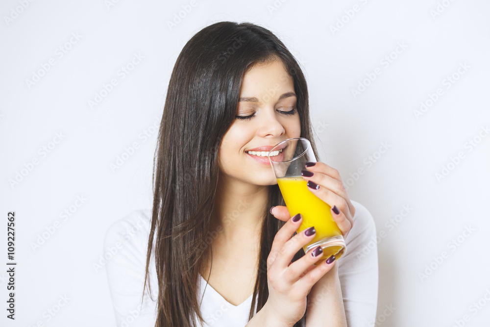 Portrait of attractive caucasian smiling woman isolated on white studio shot drinking orange juice face skin. Portrait of a pretty woman holding glass with tasty juice . Portrait of attractive caucasian smiling woman isolated on white studio shot drinking orange juice face skin. Portrait of a pretty woman holding glass with tasty juice .