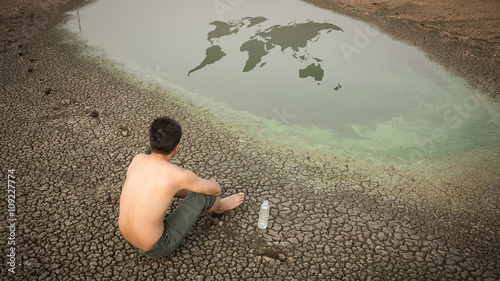 Water crisis world map, man sit on cracked earth near drying wat photo