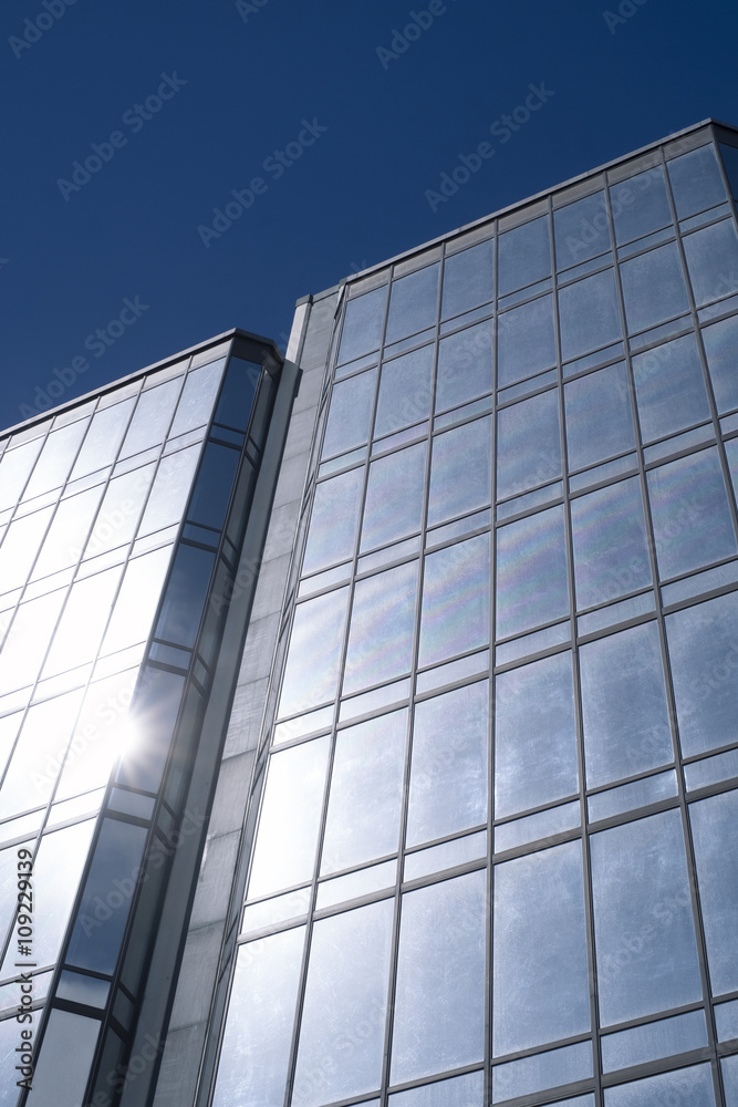 Modern offices building with glass reflecting the sunlight with a blue sky Modern offices building with glass reflecting the sunlight with a blue sky