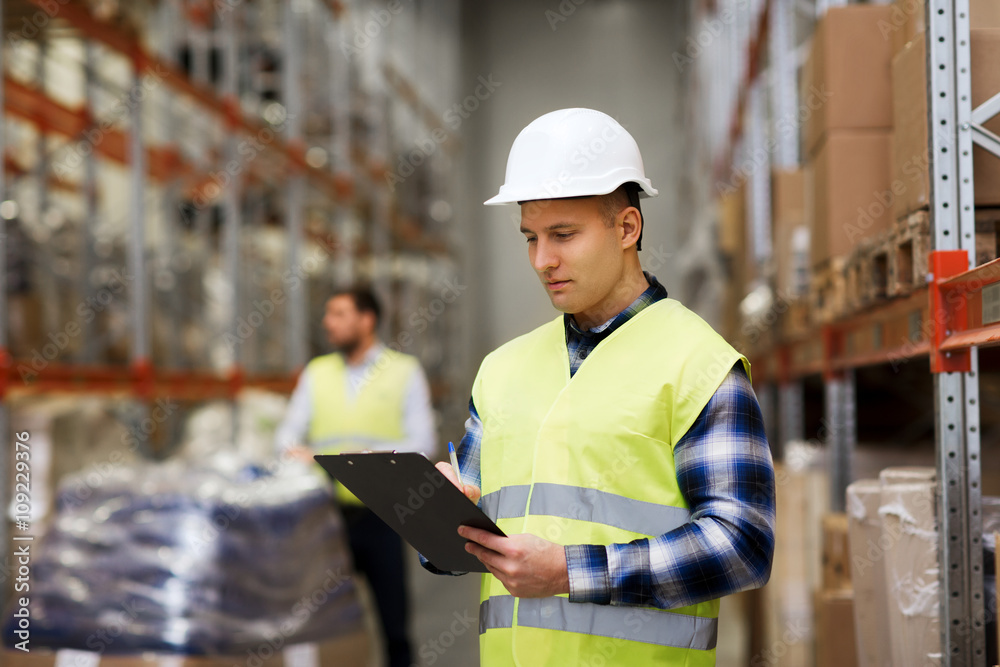 Fototapeta premium człowiek z schowkiem w kamizelce bezpieczeństwa w magazynie