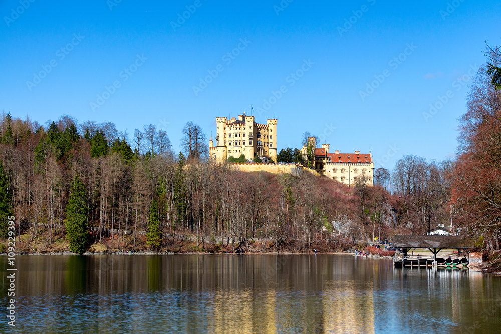 Hohenschwangau Castle, Alpsee lake, landscape view in spring, red maple fall foliage, Bavaria, Germany