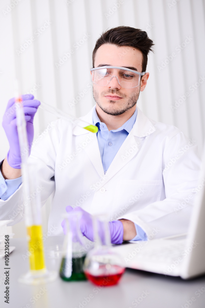 handsome young chemical biologist working in a laboratory handsome young chemical biologist working in a laboratory
