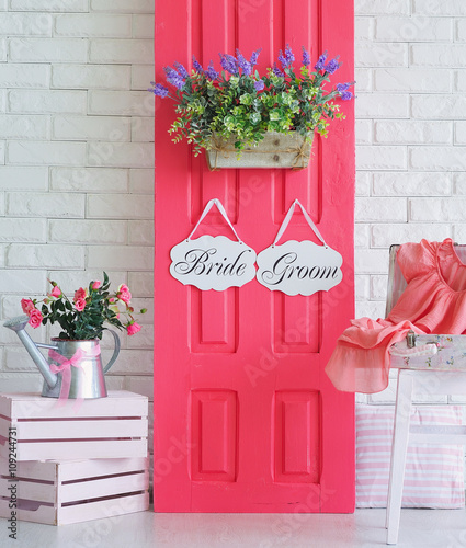 Shooting location for bride and groom decorated with pink design element, boards, and bright flowers