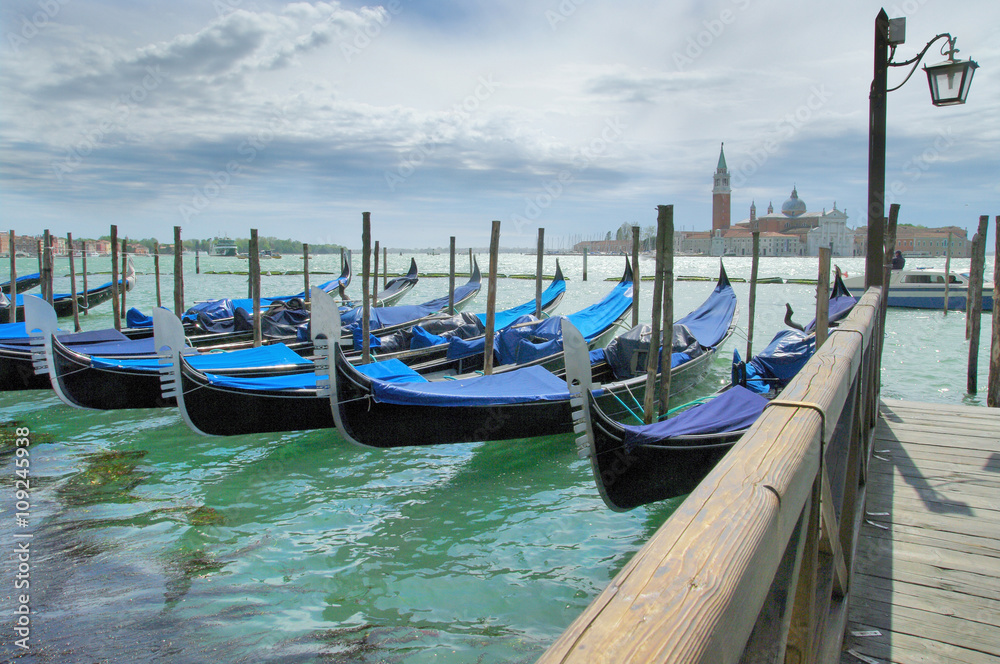 Gondolas moored by Saint Mark square with San Giorgio di Maggiore church in the background - Venice, Venezia, Italy, Europe