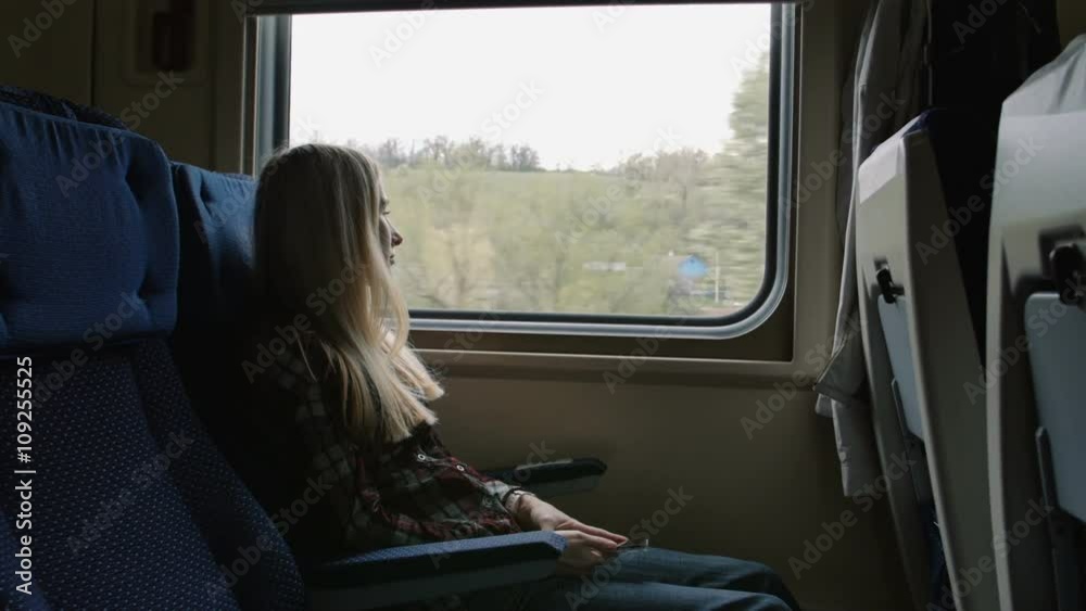 Young caucasian Woman look thru the window while traveling by train