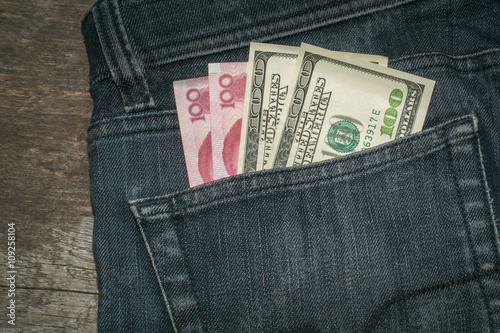 American Dollar and China yuan in the Pocket of the Jeans. Сloseup.