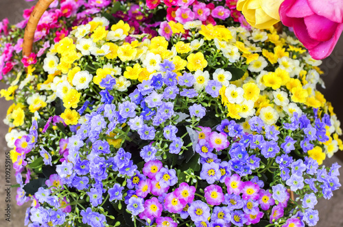 Artificial flowers of different colors in the basket © esbuka