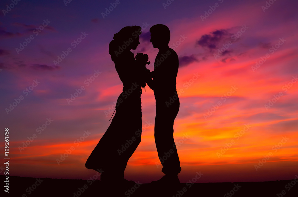 Silhouette of a loving couple against the evening sky, sunset