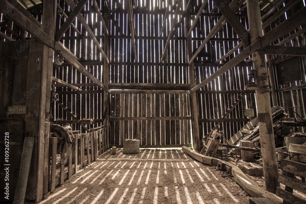 Morning Light. Morning sunlight illuminates the interior of a barn. This is a barn open to the public on public park lands, it is not a privately owned property. - obrazy, fototapety, plakaty 