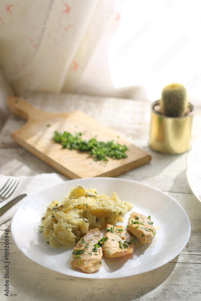 Grilled chicken fillets marinated in lemon juice and olive oil, with mashed potatoes cooked with sour cream and parsley. More parsley on the side. Selective focus. Grilled chicken fillets marinated in lemon juice and olive oil, with mashed potatoes cooked with sour cream and parsley. More parsley on the side. Selective focus.