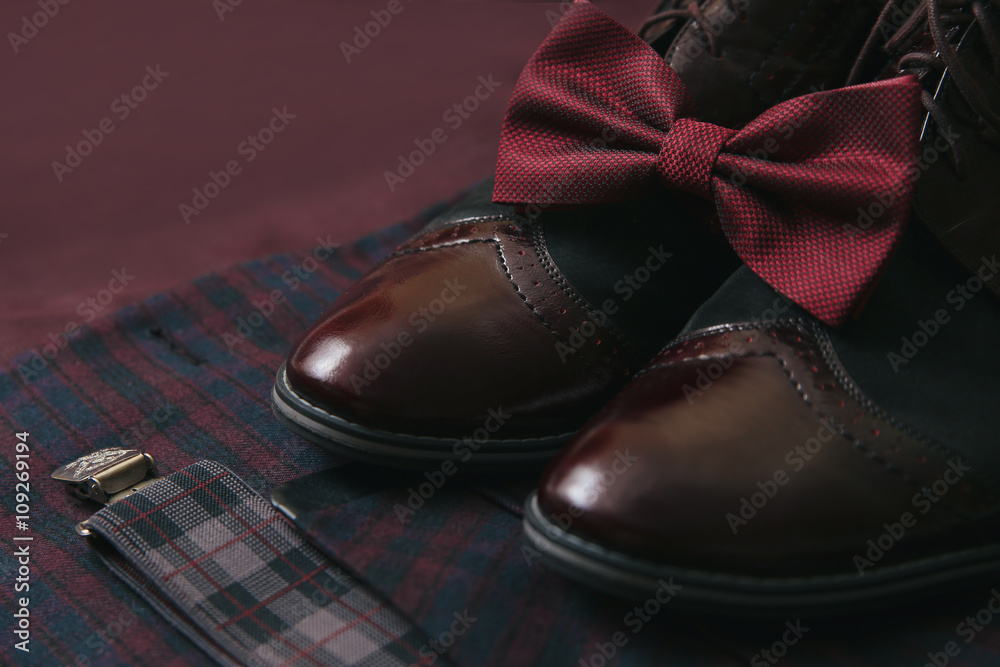 Men's accessories - bow tie, wedding rings, cufflinks on textile background.