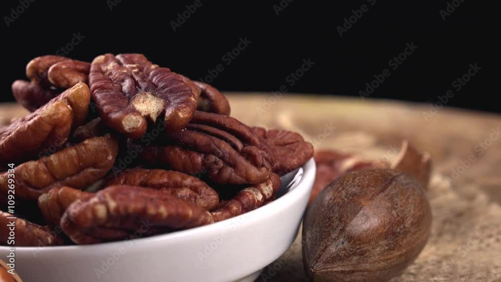Portion of rotating Pecan Nuts (not loopable 4K footage) on wooden background Portion of rotating Pecan Nuts (not loopable 4K footage) on wooden background