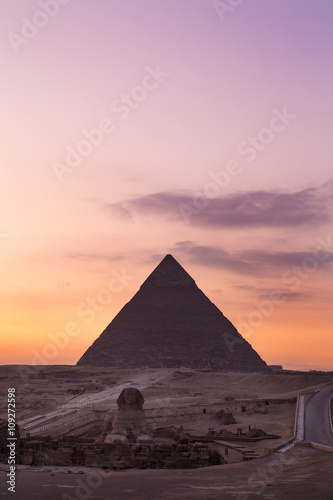 The Sphinx at sunset with great pyramid of Giza in background.