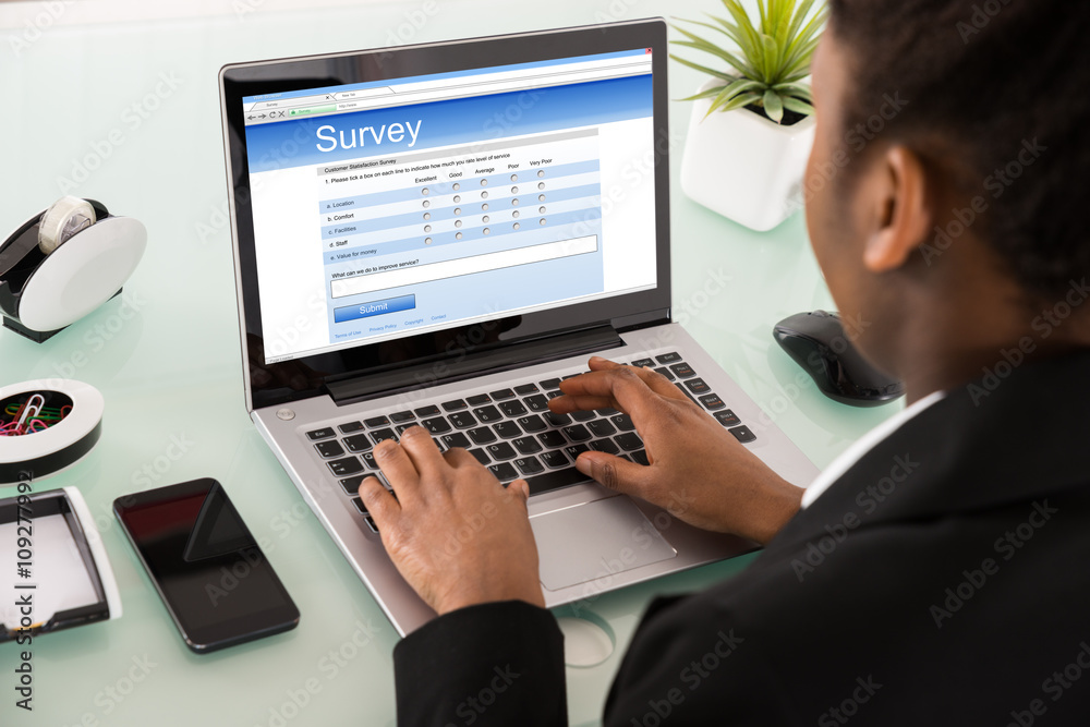 Close-up Of A Businesswoman Filling Online Survey Form Close-up Of A Businesswoman Filling Online Survey Form