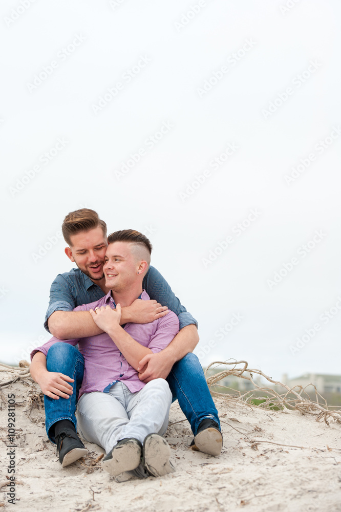 Gay men embracing on a beach