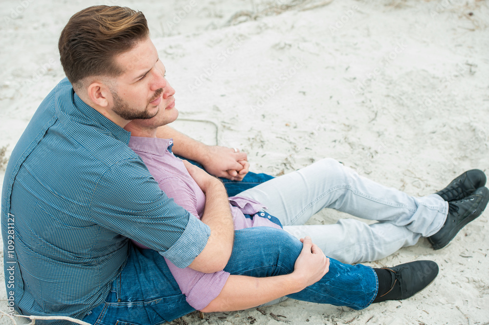 Gay men embracing on a beach Gay men embracing on a beach
