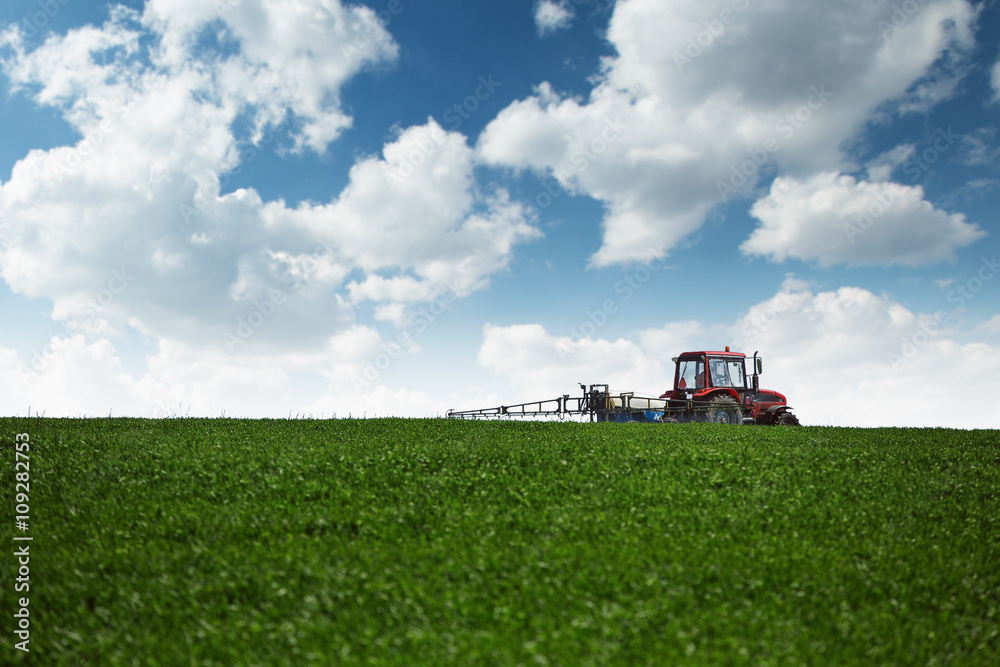 Tractor spraying wheat field with sprayer Tractor spraying wheat field with sprayer