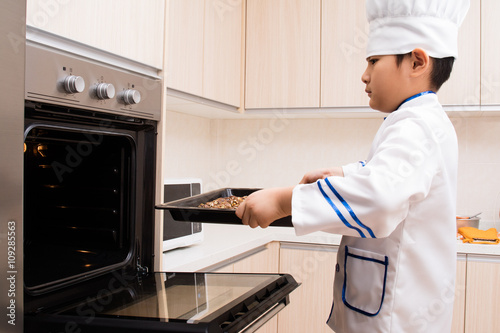 Asian Chinese Boy in white chef uniform Baking Cookies