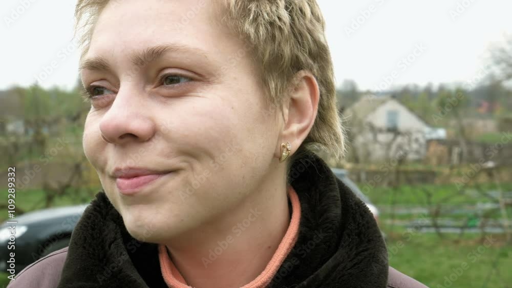 Country blond short hair girl portrait outdoors in the vegetable kitchen garden outside the house. Country rural scene. 4K UHD video footage. Country blond short hair girl portrait outdoors in the vegetable kitchen garden outside the house. Country rural scene. 4K UHD video footage.
