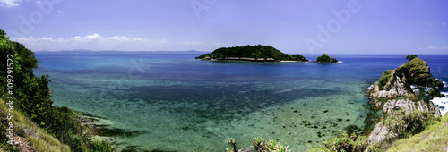 panorama view from hill top at Kapas Island, Terengganu, Malaysia surrounded by crystal clear water, coral, island and blue sky background.