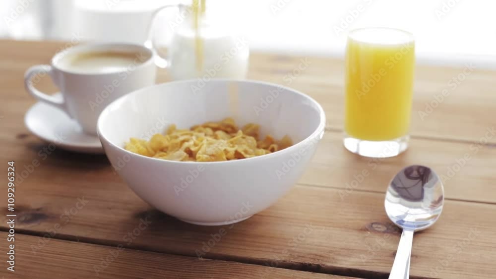 corn flakes pouring to bowl and coffee on table corn flakes pouring to bowl and coffee on table