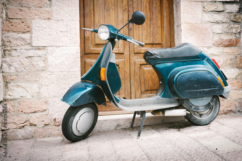 Old Italian scooter in front of the door